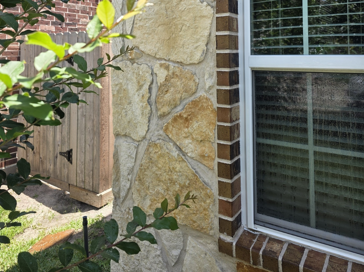 Natural limestone stone wall on home in Lakewood Forest Cypress TX before professional cleaning, showing weathered dull surface and faded stone color